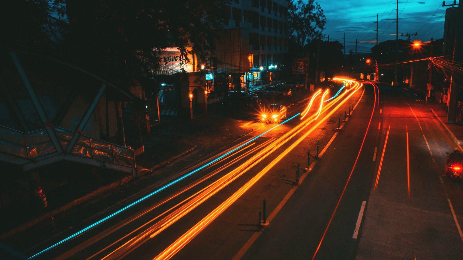Coral light trails streaking down a night street